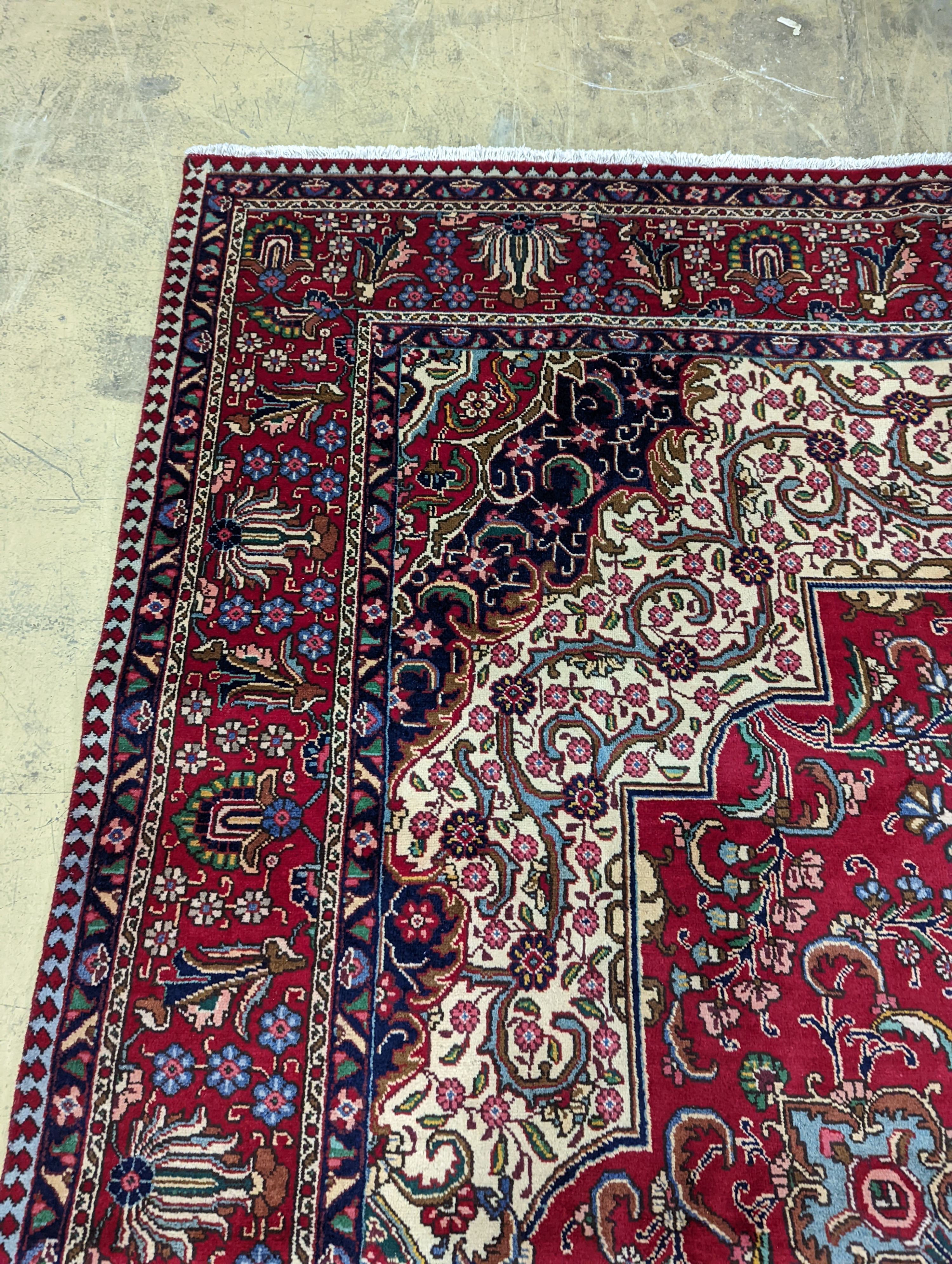 A Tabriz red ground carpet, 405 x 292cm